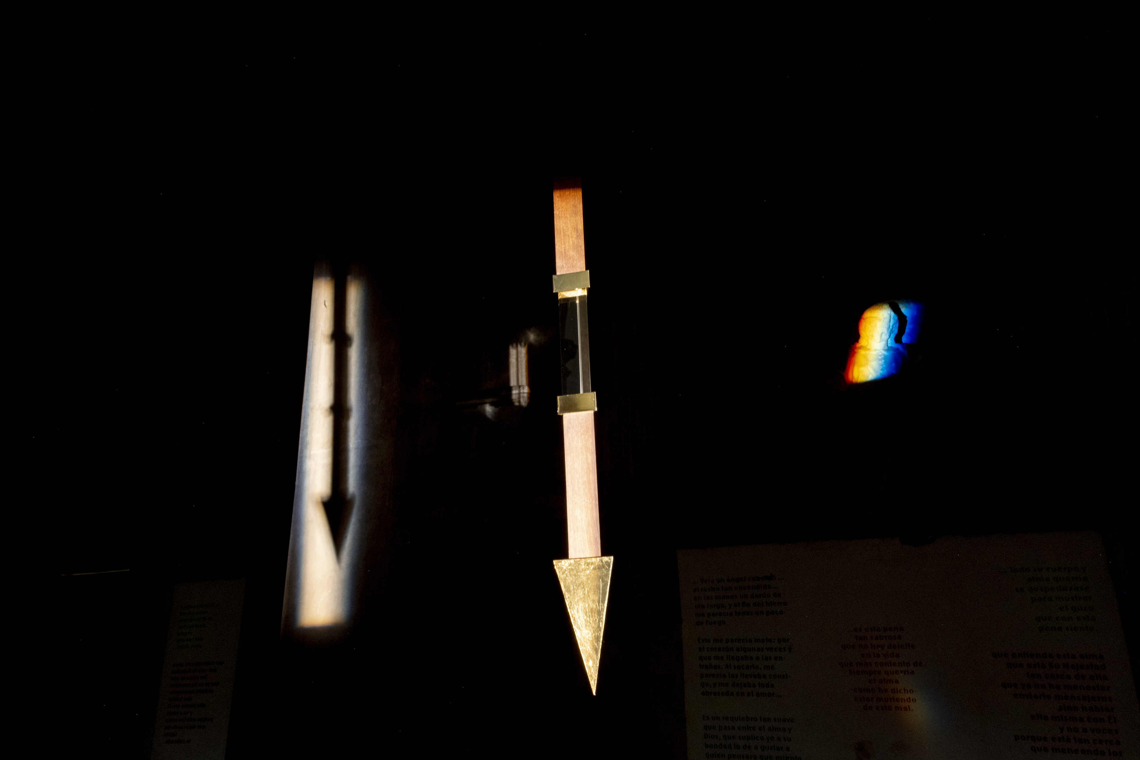 Transverberación/Transverberation,  2022 
Instalación con Espejos, Flecha de nogal con prisma de cristal, latón, y hoja de oro, citas de Santa Teresa de Ávila, Iluminación. Installation wit 2 mirrors, walnut arrow with a crystal prism, brass and gold leaf, quotations from St Teresa of Avila, lighting. 